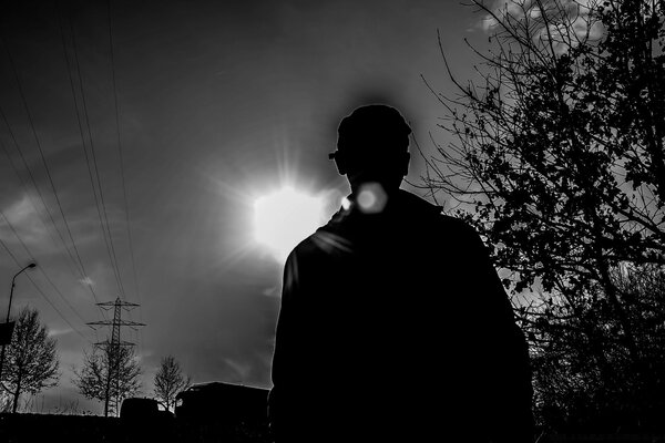 Black and white silhouette of a man on the background of sunset