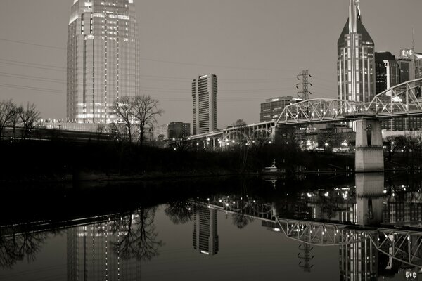 En la ciudad, el puente sobre el río en blanco y negro