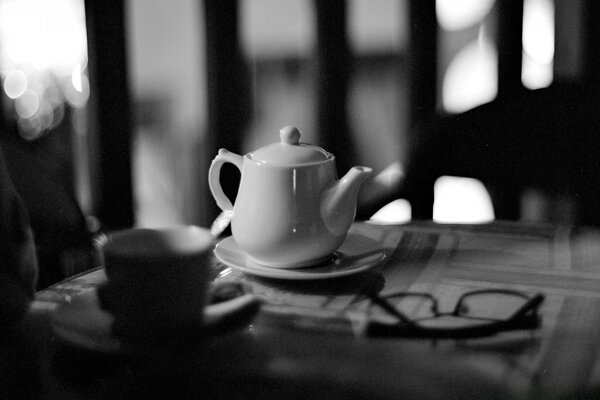 Teapot on the table still life monochrome in black and white light