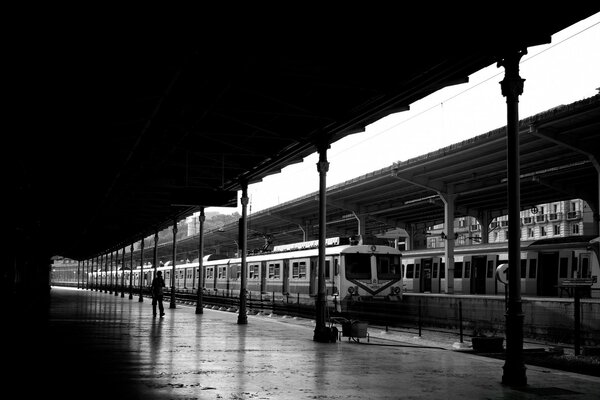 Black and white railway station, a lonely man on peron