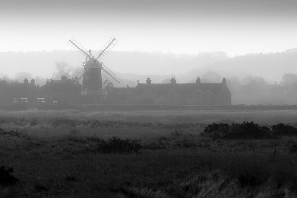 Landscape windmill in the fog in the evening