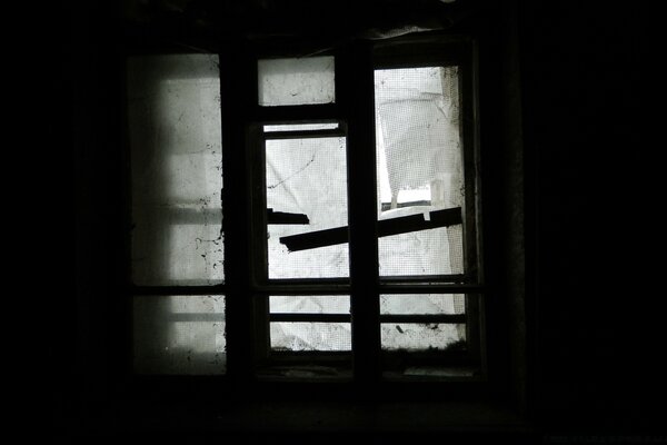 The broken window of an abandoned house