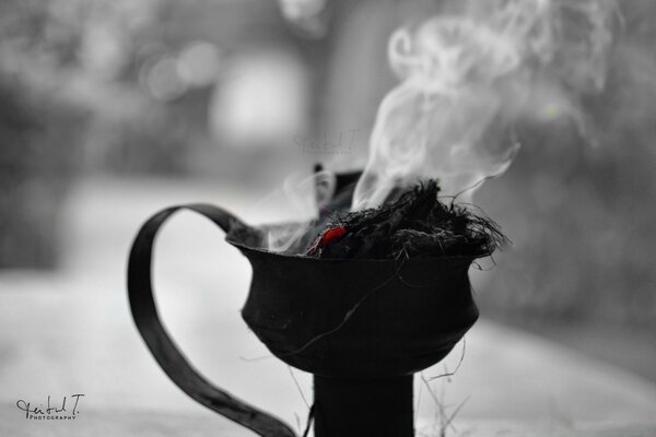 Black and white photo of a jug with smoking grass