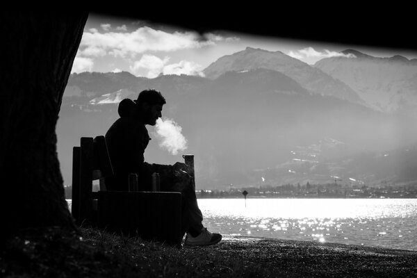 Mann raucht am Teich Foto