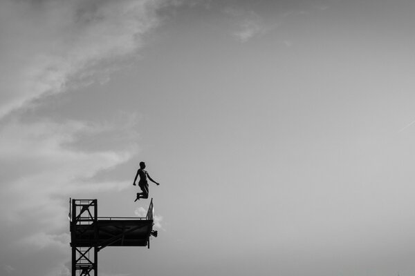 Jump from a tower against the sky in black and white