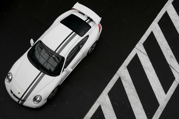 Coche blanco estacionado cerca de la marca