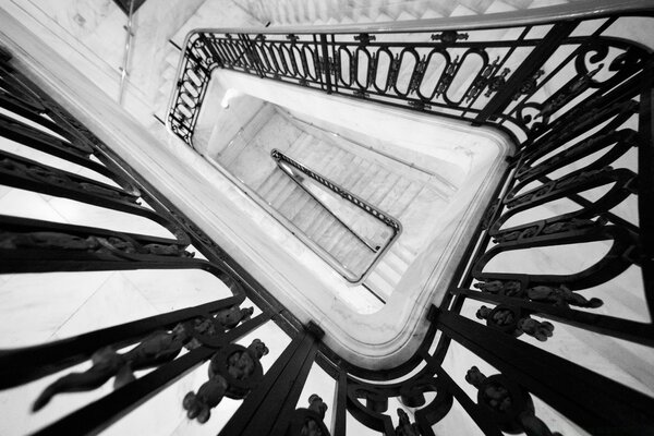 Escalera en blanco y negro con barandillas forjadas