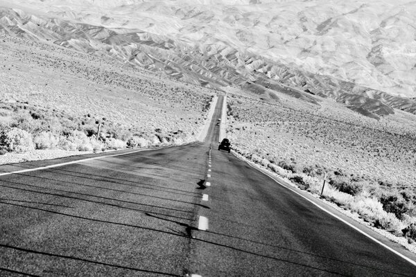 A road in a desert area against the background of mountains