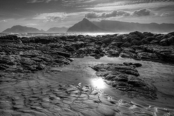 Black and white mountains in the distance and low tide ocean view from the window