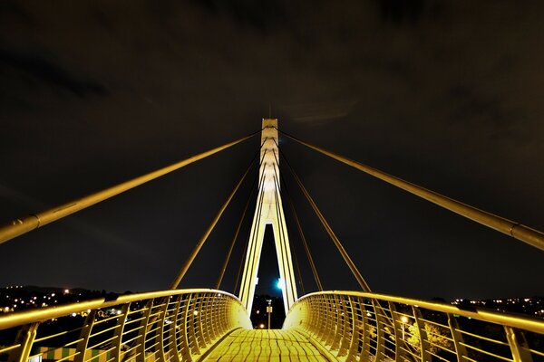 Puente iluminado por linternas y ciudad visible