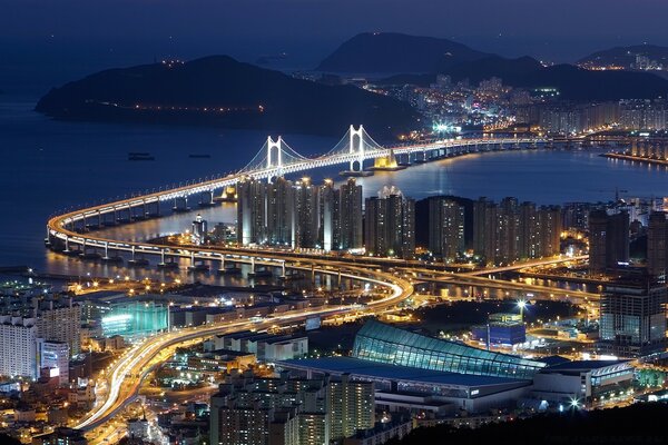 Cidade noturna ilumina o mar adjacente