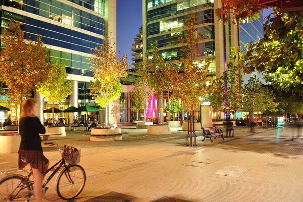 A girl on a bicycle in the evening city