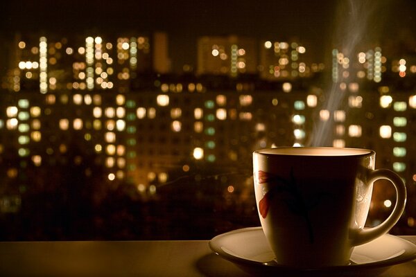 Tasse avec soucoupe sur fond de lumières de la ville