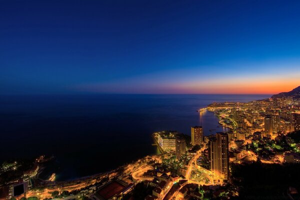 Night city landscape on the background of the sea