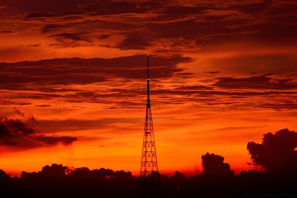 The TV tower stands against the background of a fiery sky