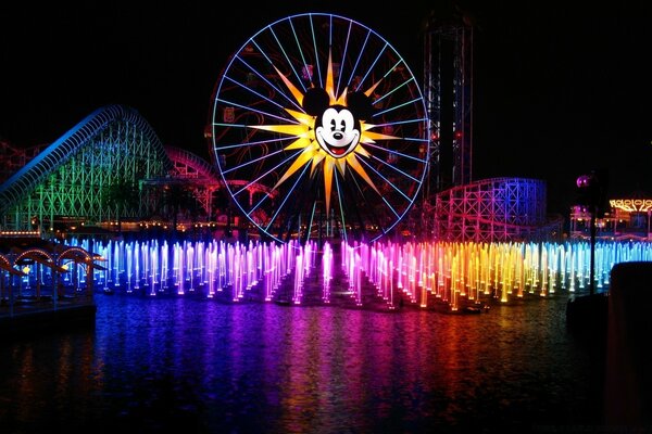 Ferris wheel with an image of Mickey Mouse on the background of fountains