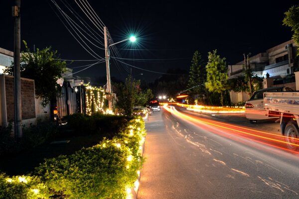 Calle nocturna con trazas de faros de coche