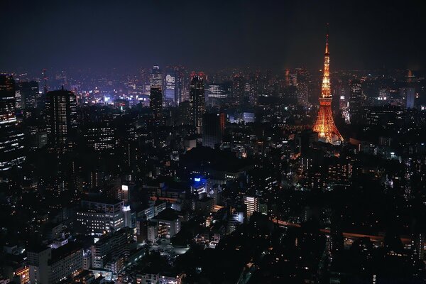 Torre iluminada em uma grande metrópole