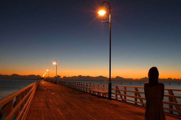 Figura solitaria en el puente sobre el río