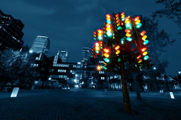 A tree of traffic lights in the middle of a gray city