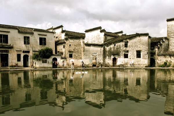 The building is gray, reflected in the water