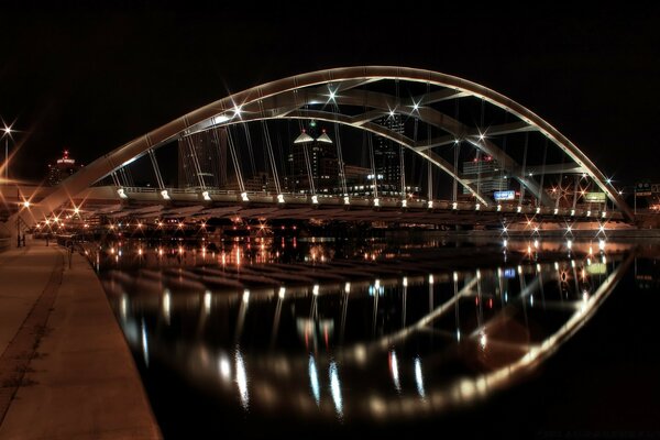 The night bridge is reflected in the water