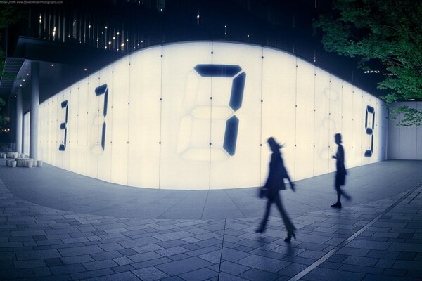 People on the street against the background of glowing panels with numbers