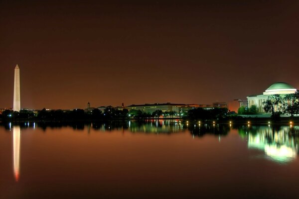 Reflection of sunset in another city on the background of water