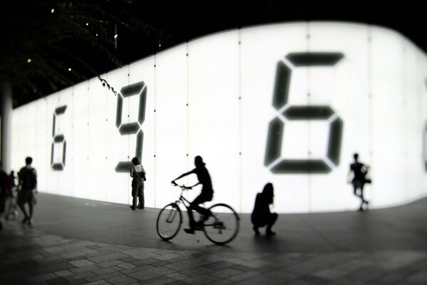 A man on a bicycle along the fence