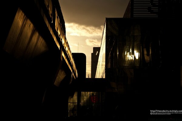 Silueta oscura de otra ciudad al atardecer en la luz que se abre paso