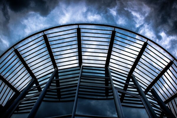 Glass roof on the background of the sky with clouds