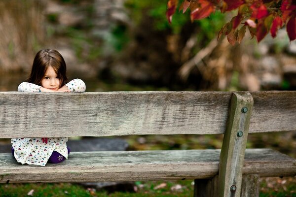 Petite fille sur un vieux banc