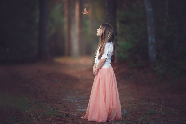 Ein Kind in einem schönen Kleid im Wald