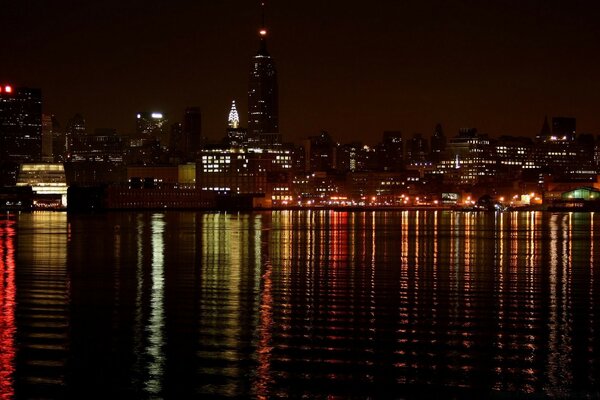 Night city on the shore of a water bay