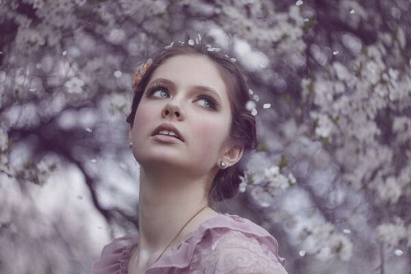 Fille regardant de côté sur fond de fleurs blanches