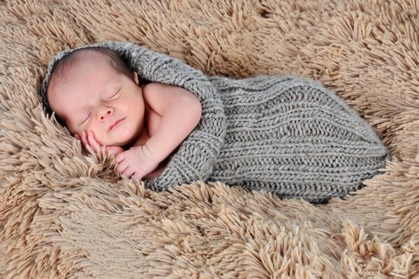 Новорожденный сладко спит в мехе