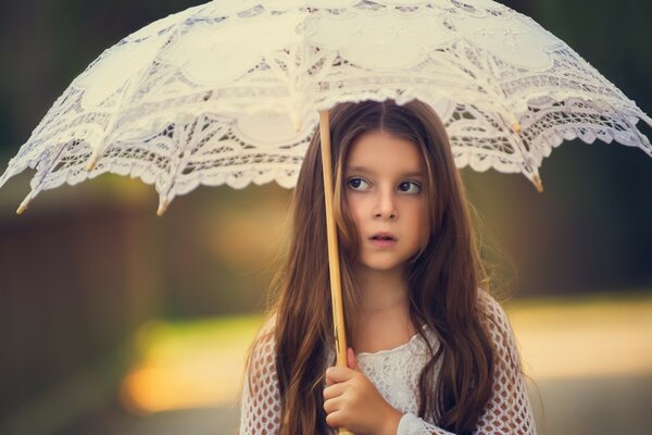 Menina com guarda-chuva branco e fundo desfocado