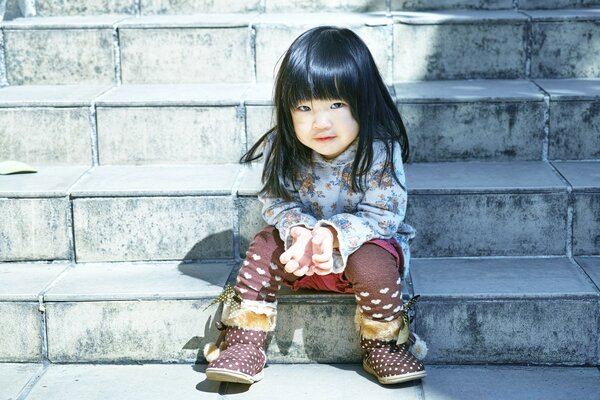 Petite japonaise assise sur les escaliers