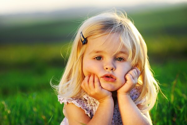 Petite fille posant sur l herbe verte