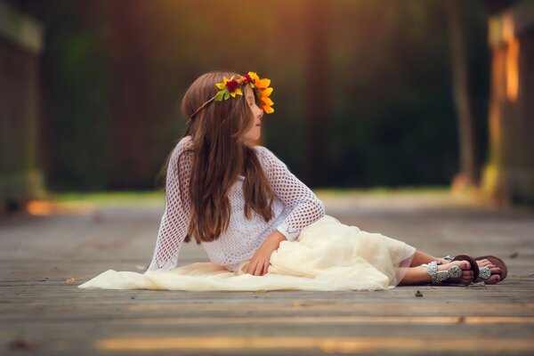 A child with a wreath is lying on the floor