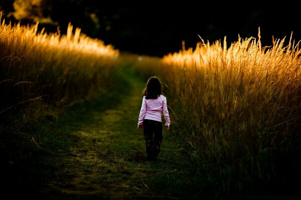 Fille sur fond de coucher de soleil va au loin