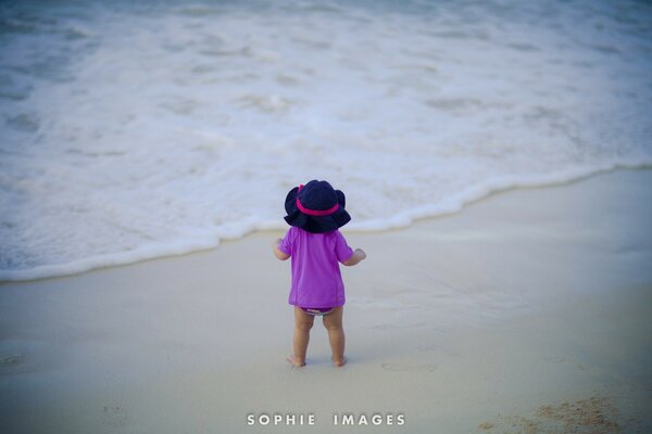 Enfant en lilas sur la plage de sable