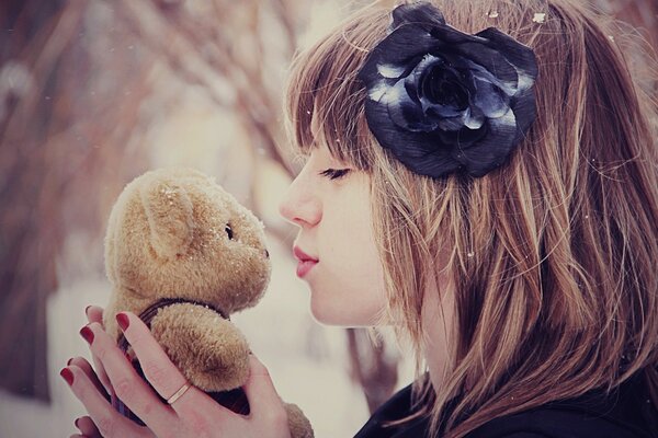 Menina beijando urso de pelúcia