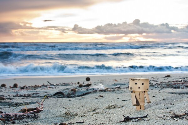 Spiaggia deserta con un ometto di cartone solitario