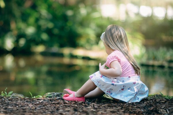 A dreamy girl is sitting on the shore