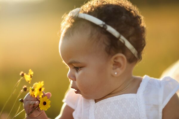 La bambina annusa il fiore