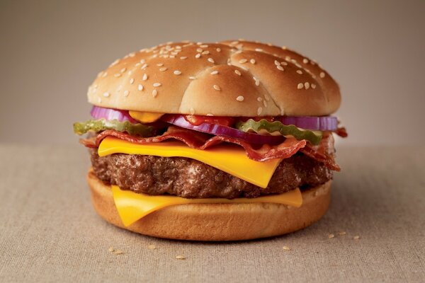 A cheeseburger with a huge cutlet is lying on the table