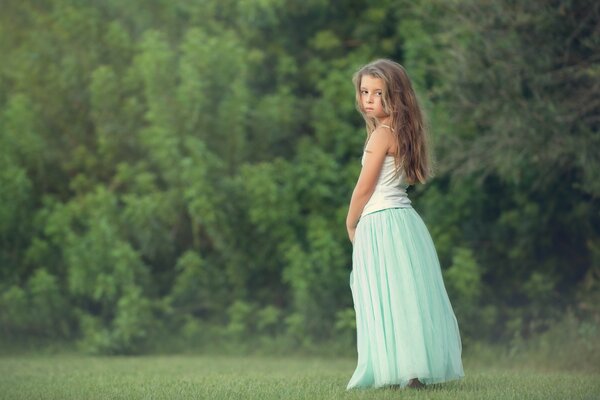 Beautiful girl on a forest background in a long skirt