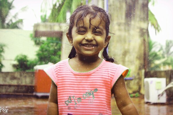 Niña riendo bajo la lluvia