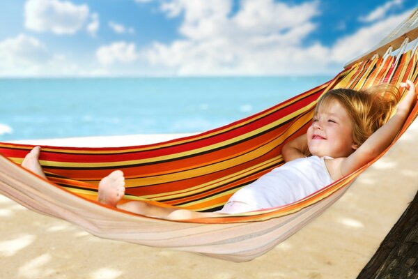 A child in a hammock, the beach and the sea